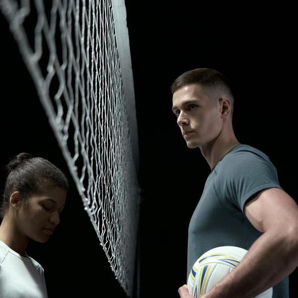 Silhouette of a man in a balanced strength pose against a dark background.